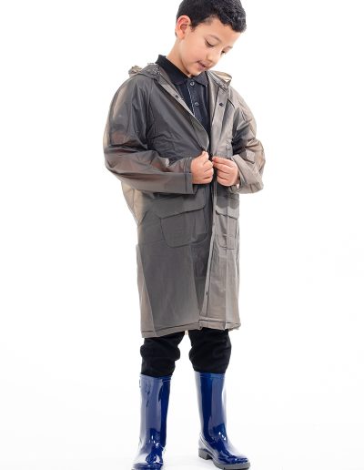 Kid wearing a transparent black waterproof coat and blue boots