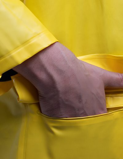Detail of a hand wearing a waterproof coat with hood