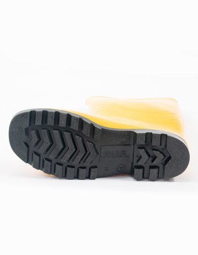Detail of the sole of a yellow rubber safety swamp boot
