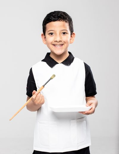 Painter boy wearing a white waterproof apron