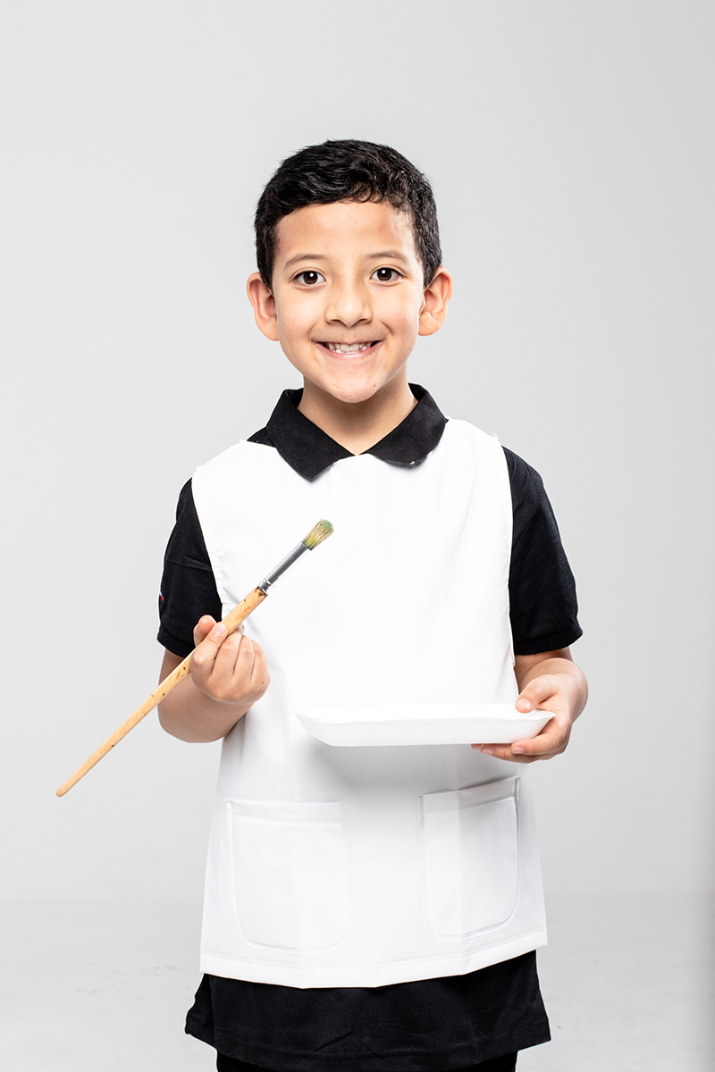 Painter boy wearing a white waterproof apron